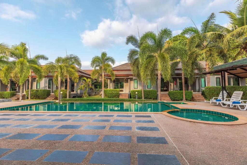 a villa with a swimming pool and palm trees at Modern 2-Bedroom Villas with Pool Access in Krabi town