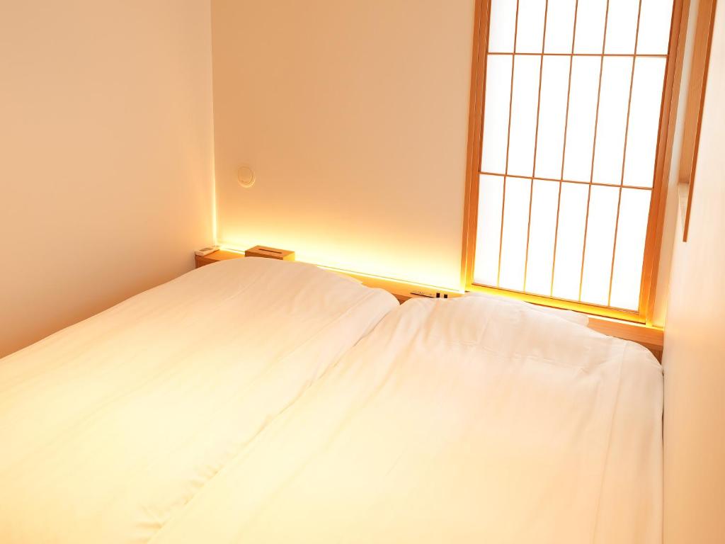Postel nebo postele na pokoji v ubytování 大日寺の宿 京都吉祥院