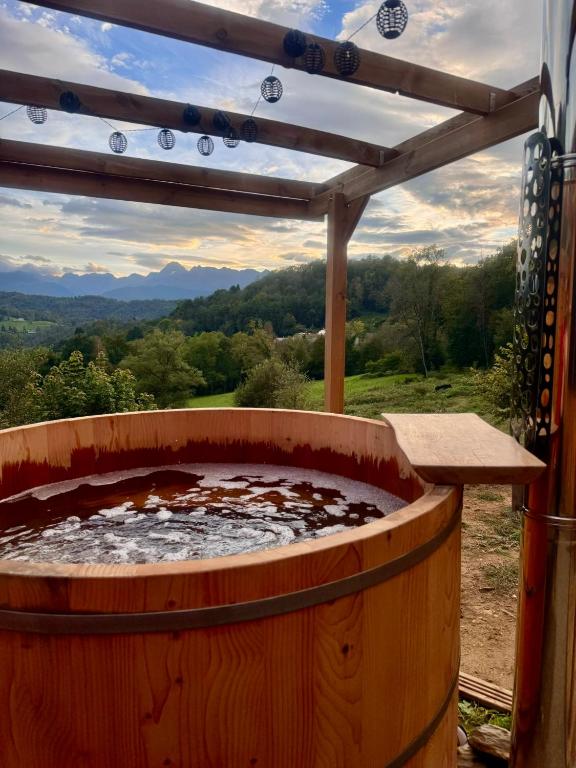 un bain à remous dans un tonneau en bois avec une pergola dans l'établissement Cottage du Mauberme avec bain nordique, à Soulan