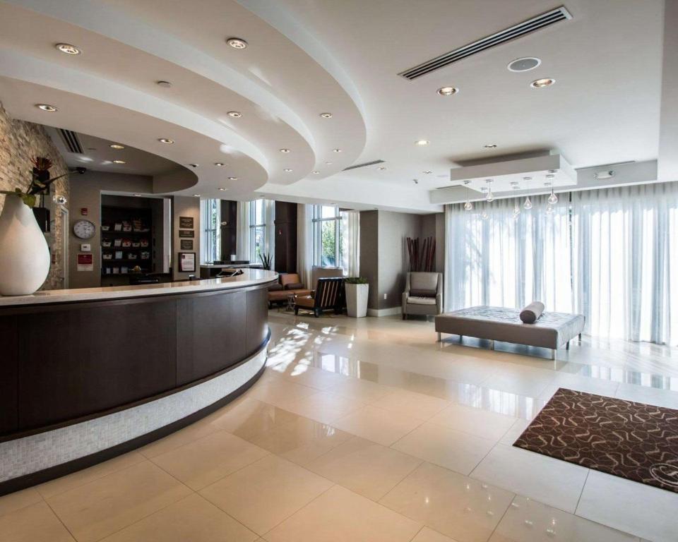 a lobby with a bar and a couch in a building at Comfort Suites Miami Airport North in Miami