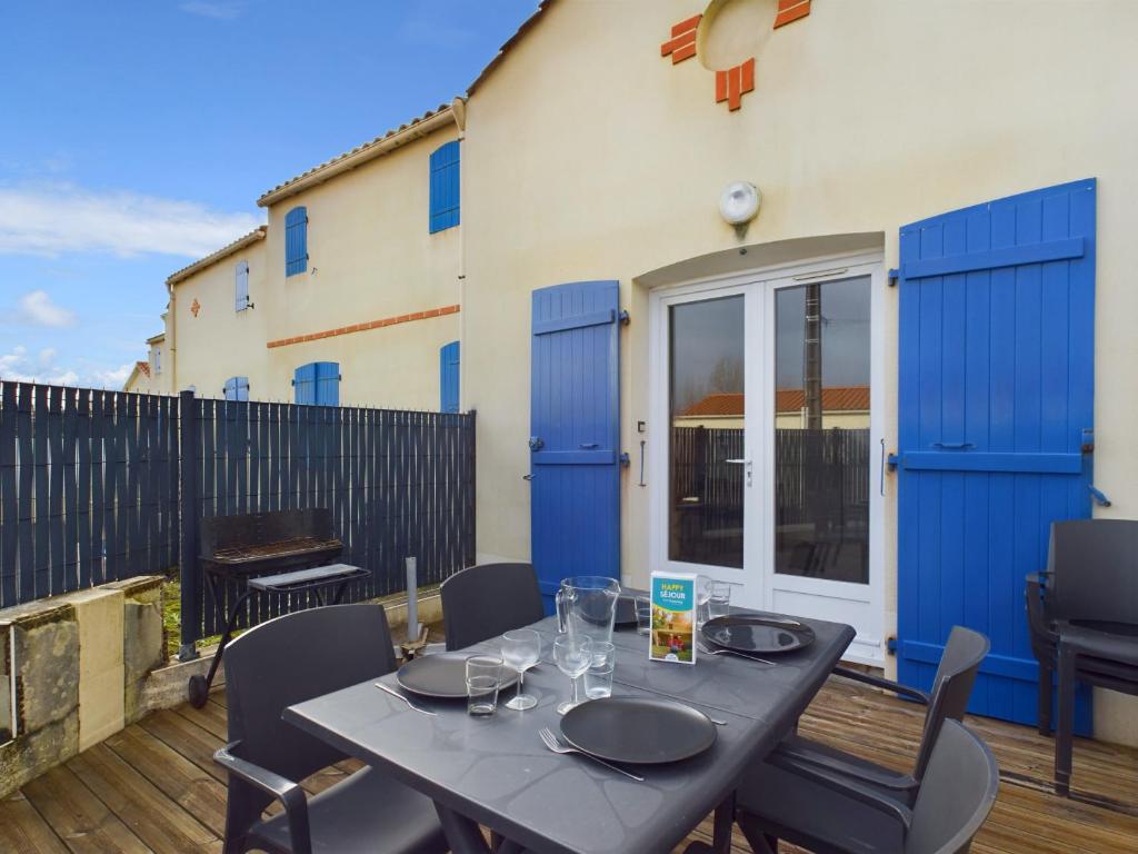 a patio with a table and chairs and a building at Saint-Hilaire - 350m de la plage in Plage-des-Demoiselles