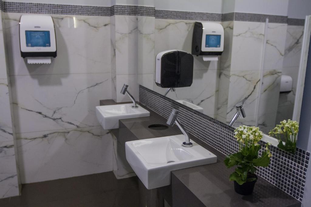 a public bathroom with two sinks and a mirror at Fratele Business Hotel in Patos de Minas