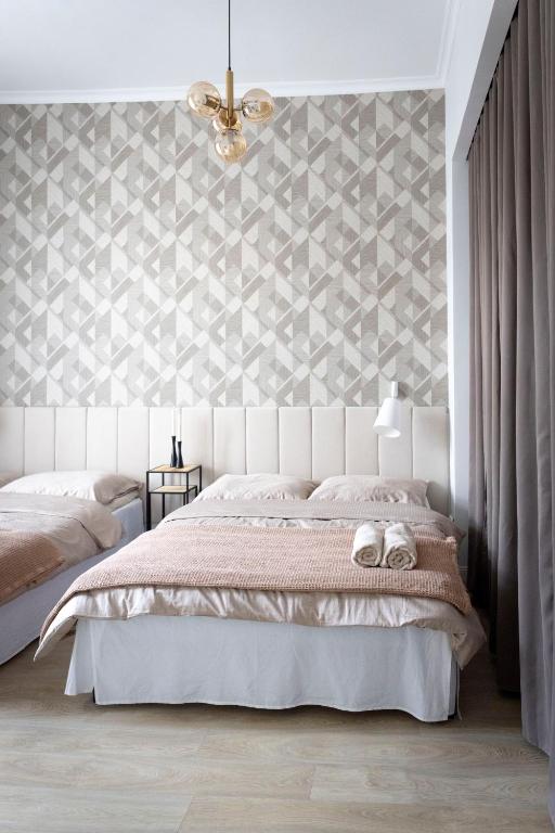 a bedroom with a white bed and a diamond patterned wall at Magnolia 1 in Gliwice
