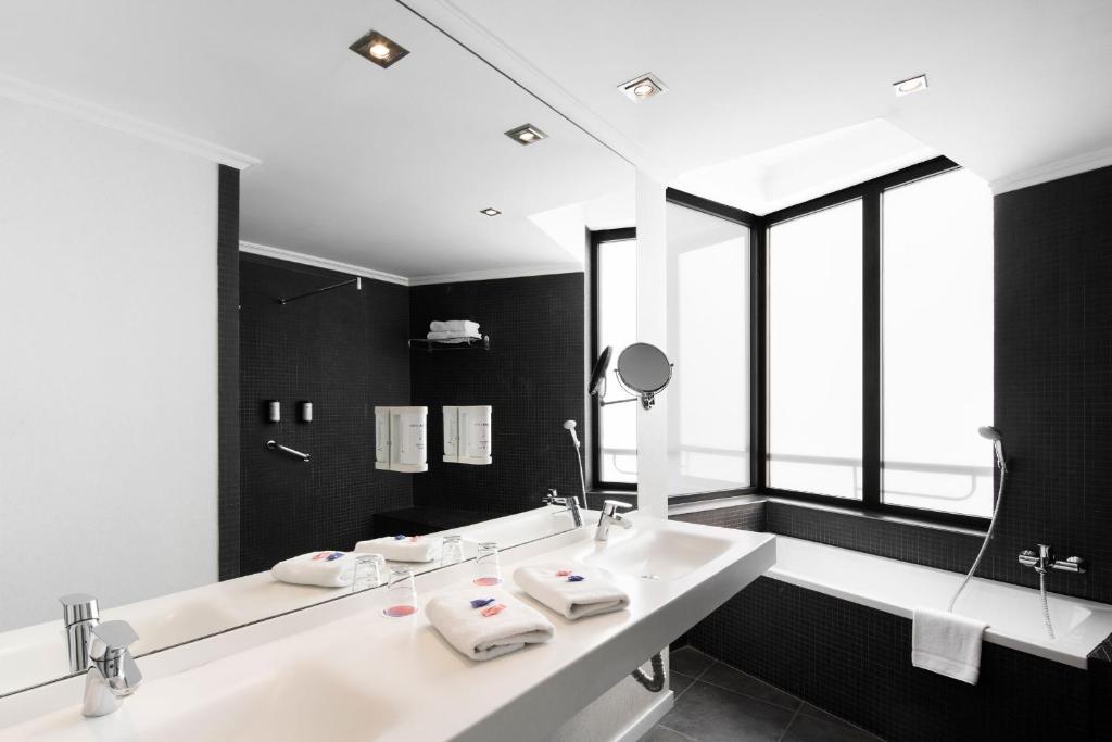 a bathroom with two sinks and a large mirror at Hotel Alimara in Barcelona