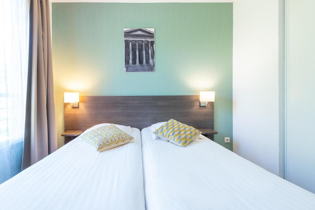 Postel nebo postele na pokoji v ubytování Comfort Aparthotel Nimes Centre