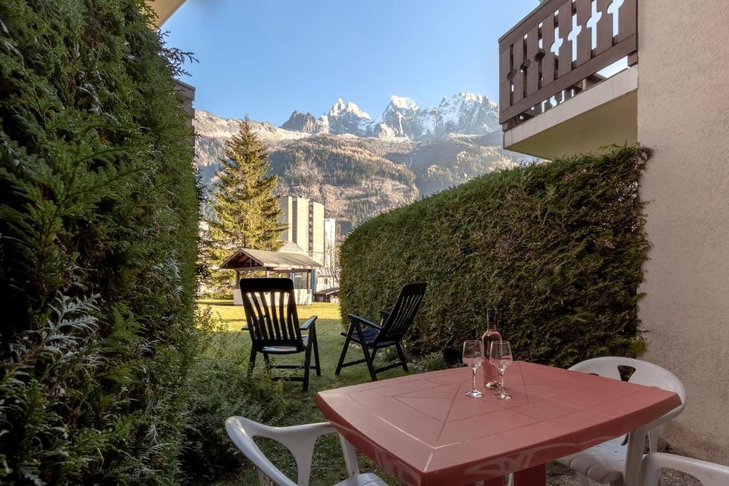 une table et des chaises avec des verres à vin sur une terrasse dans l'établissement Jardin du Mont Blanc, à Chamonix-Mont-Blanc