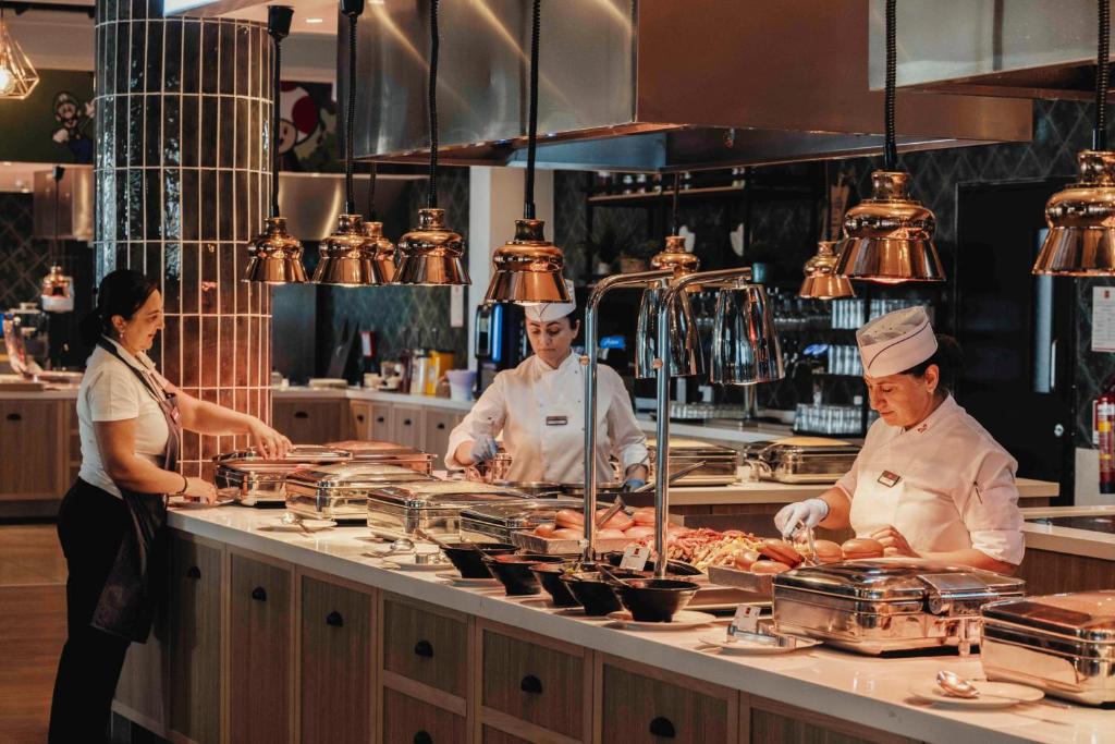 a group of chefs preparing food in a kitchen at Leonardo Cypria Bay in Paphos