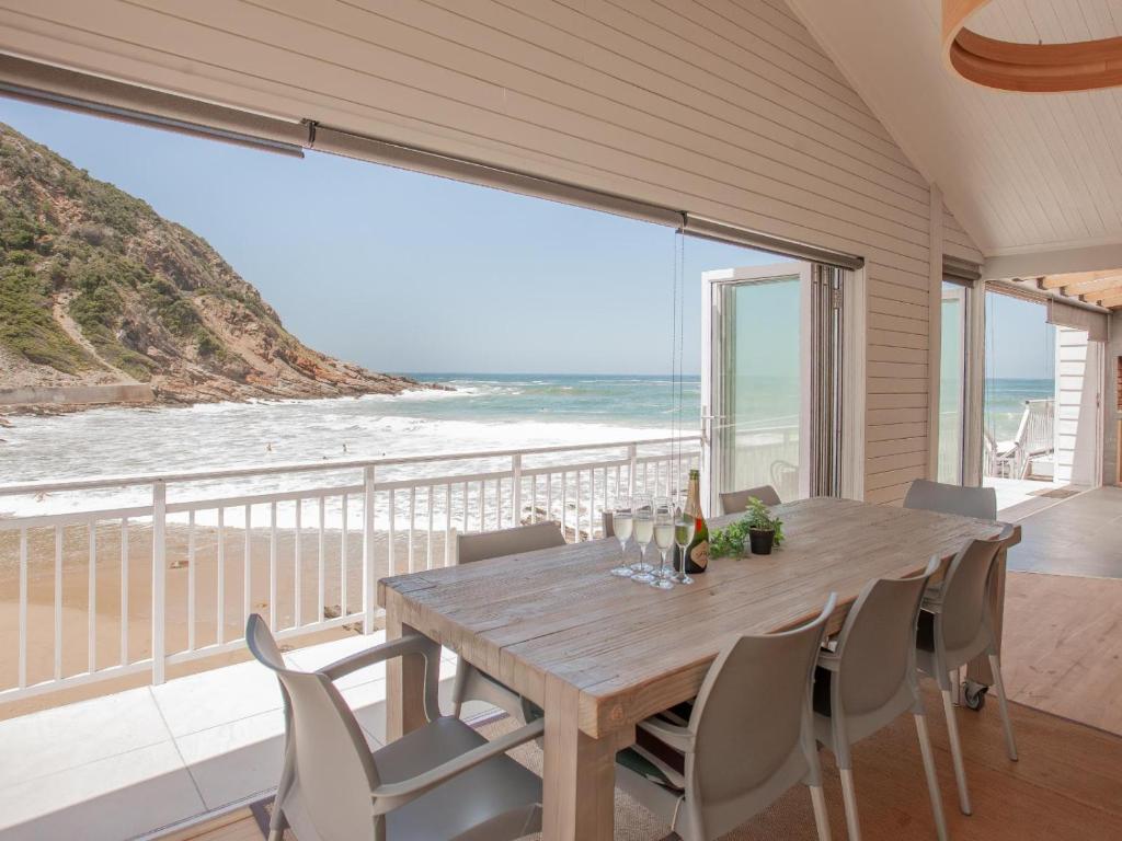 a dining room with a table and a view of the beach at Tide Over in Victoria Bay