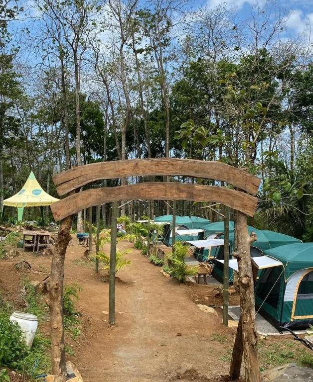 un arco in legno con tavoli, ombrelloni e tende di Puri kahuripan a Pagungjoho