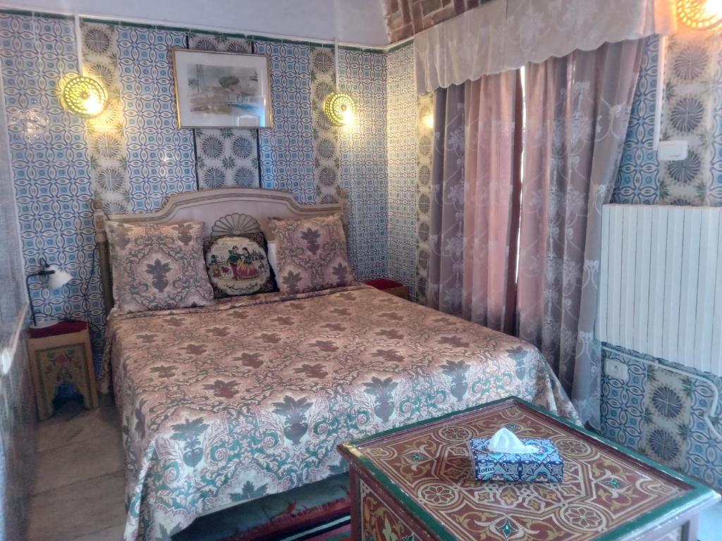 a bedroom with a bed with a box on a table at Hôtel Bou Fares in Sidi Bou Saïd