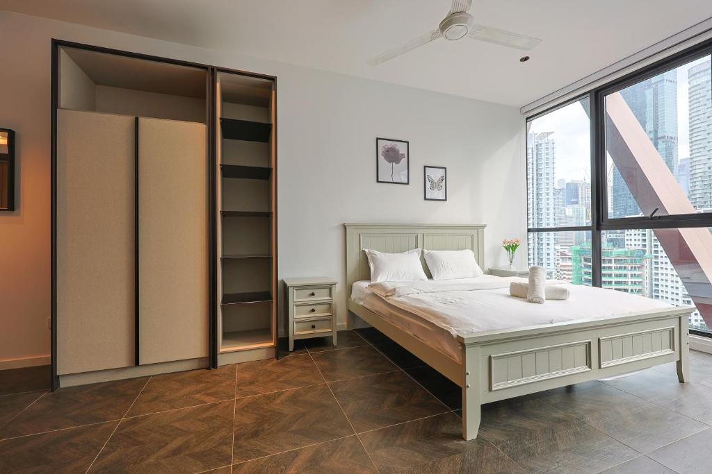 a bedroom with a bed and a large window at Borderless Swimming Pool - Invincible Twin Towers View - Free WiFi in Kampong Gombak Utara
