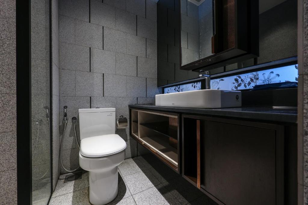 a bathroom with a white toilet and a sink at Borderless Swimming Pool - Invincible Twin Towers View - Free WiFi in Kampong Gombak Utara