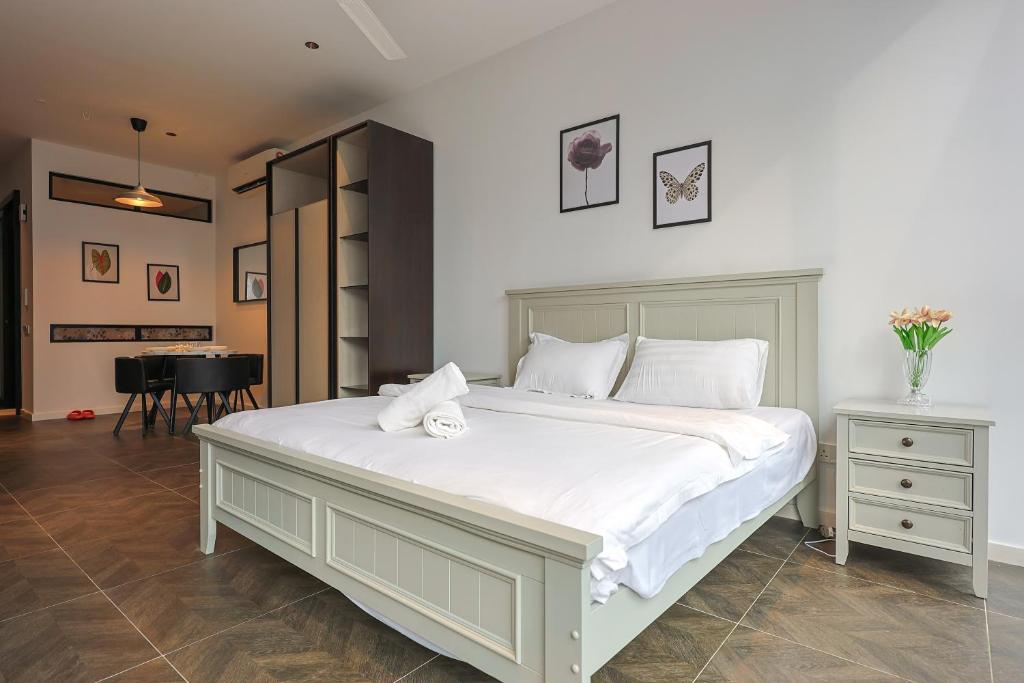 a bedroom with a large white bed and a table at Borderless Swimming Pool - Invincible Twin Towers View - Free WiFi in Kampong Gombak Utara