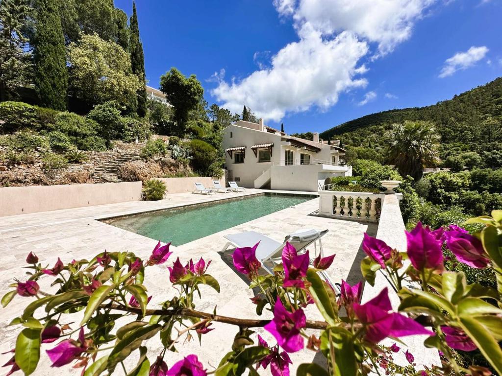 a house with a swimming pool and purple flowers at Villa Blanche pour 8 personnes avec piscine privée à La Londes-Les-Maures in La Londe-les-Maures
