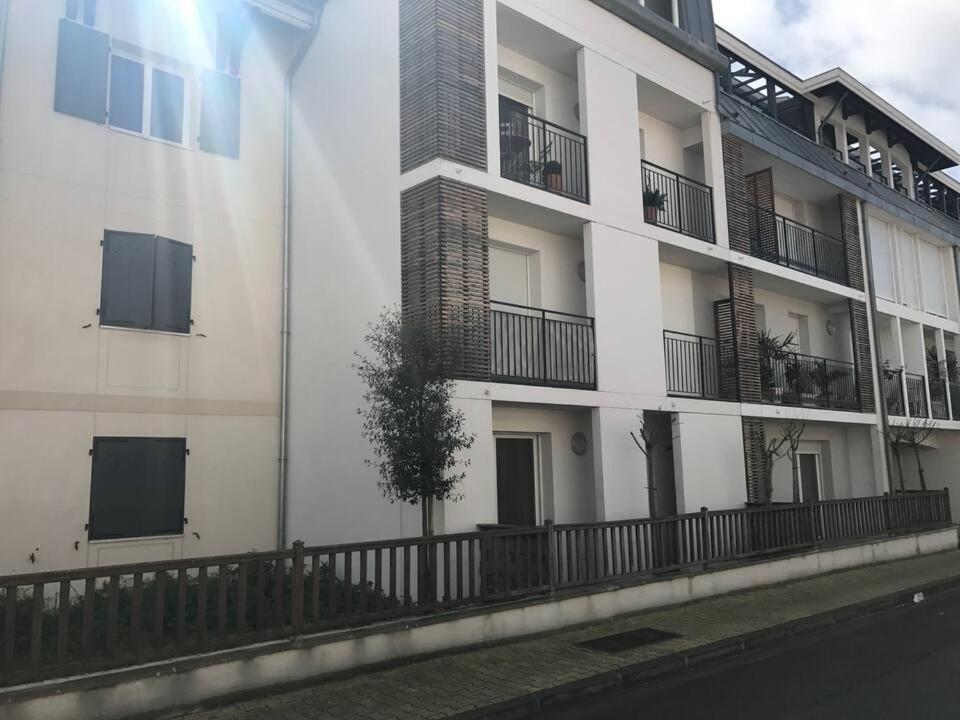 un bâtiment blanc avec des balcons sur le côté dans l'établissement Arcachon centre résidence récente, à Arcachon