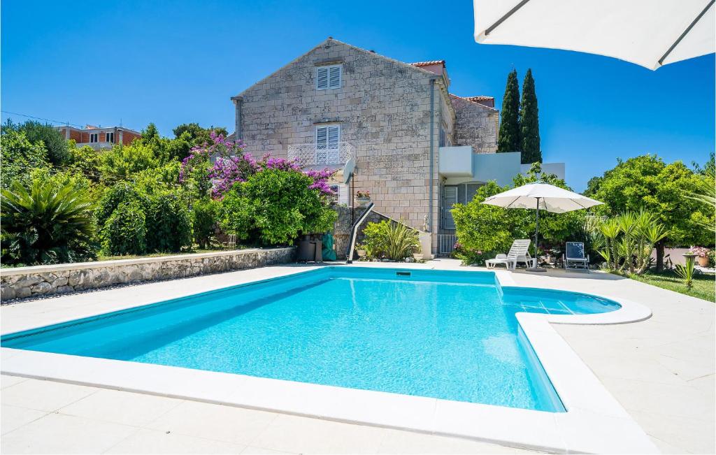 a villa with a swimming pool in front of a house at Nice Apartment In Zaton Veliki With Wifi in Zaton