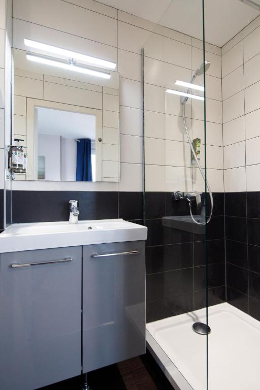 a bathroom with a shower and a sink and a mirror at Saint Aubin Logis Hôtel & Restaurant in Saint-Aubin-sur-Mer