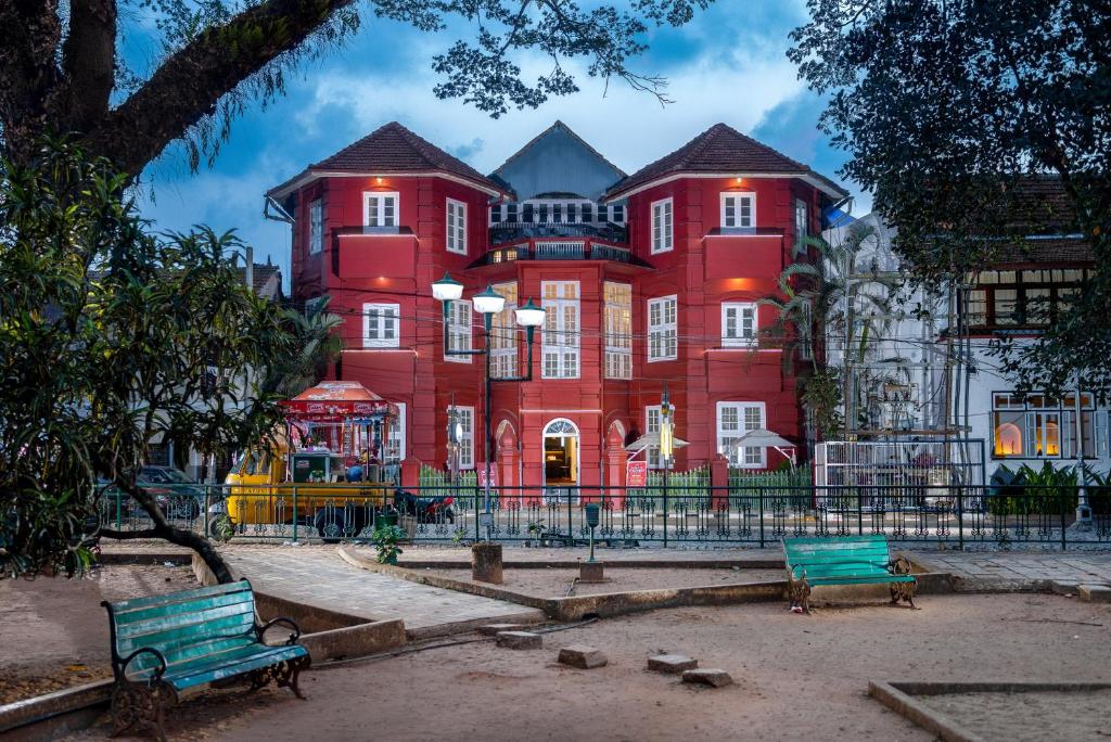 a large red building with benches in front of it at Koder House in Cochin