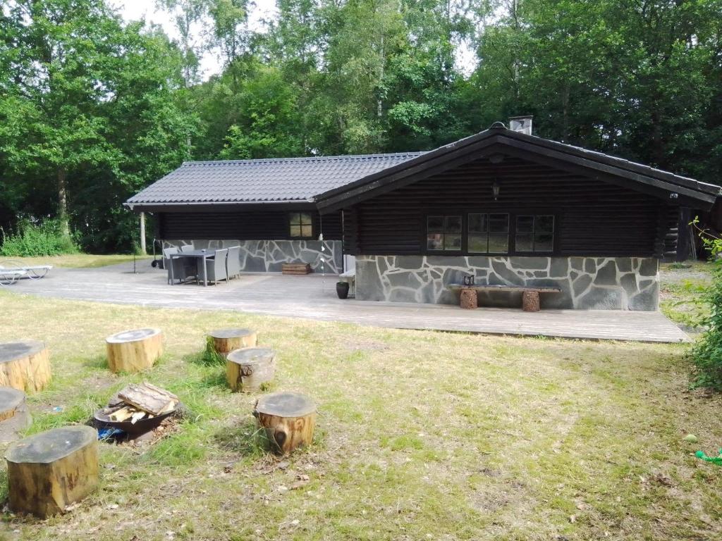 a log cabin with a bunch of logs in front of it at Beautiful Home In Aars W- in Års