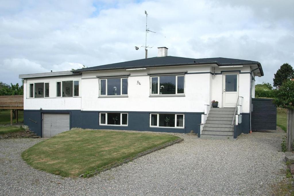 a white and blue house with a driveway at Amazing Home In Rudkøbing With 6 Bedrooms And Wifi in Spodsbjerg