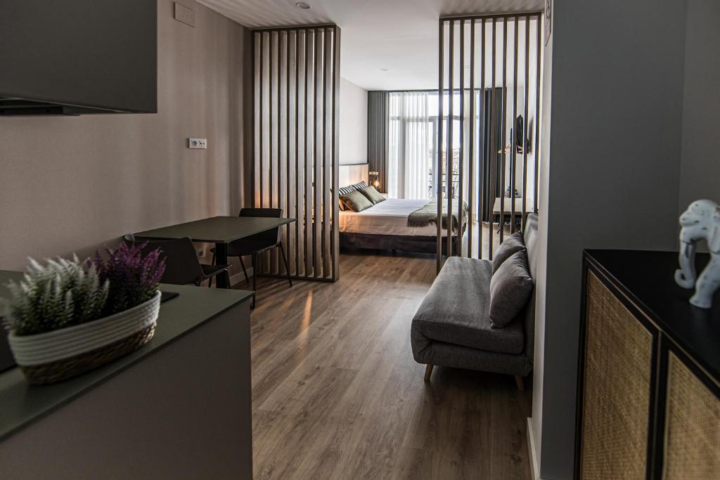 a living room with a couch and a bedroom at Apartamentos Luxury en San Juan in Badajoz