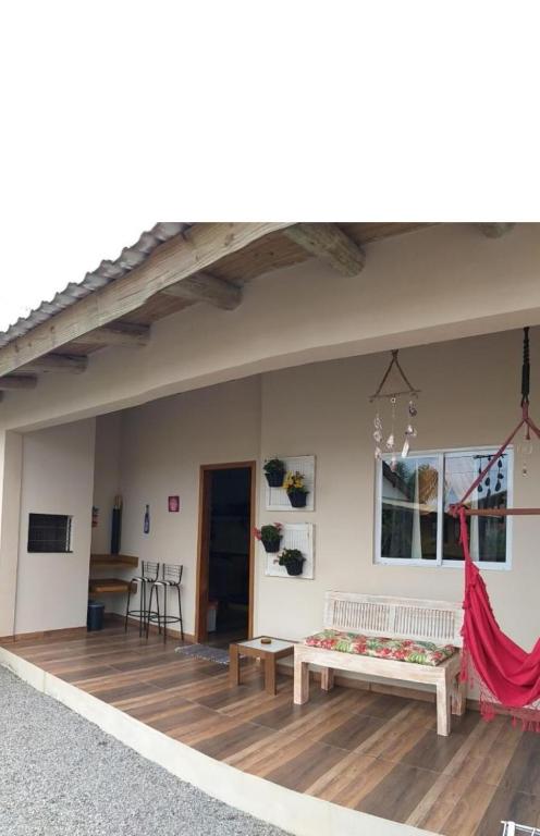 a patio with two benches on a wooden deck at Casa Natturvibe - Praia do Rosa in Praia do Rosa