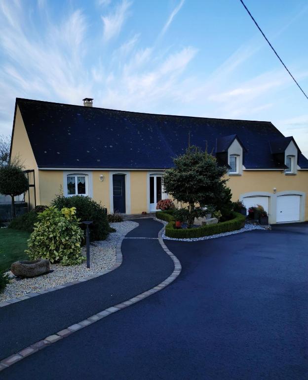 une maison avec un toit noir et une allée dans l'établissement Chambre d'hôtes Le Pot au Lait, à Villaines-la-Juhel