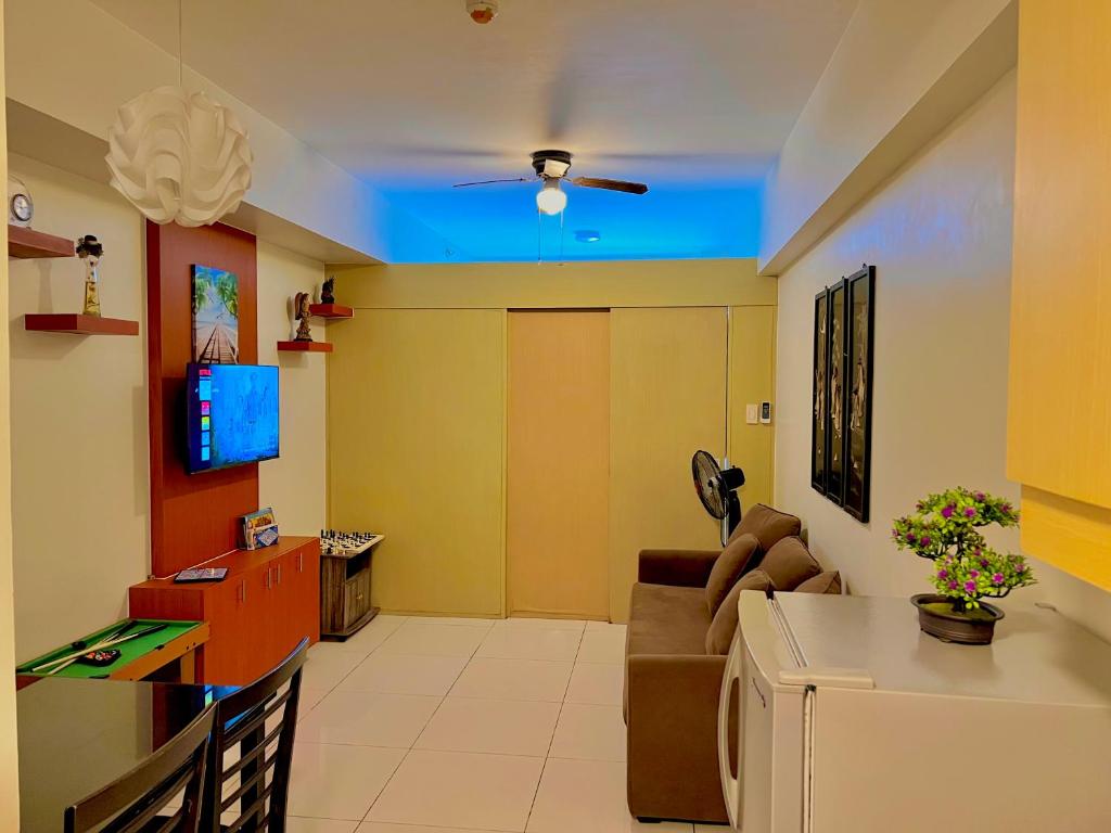 a living room with a couch and a tv at SMDC Wind Residences Tower 4 Taal view in Tagaytay