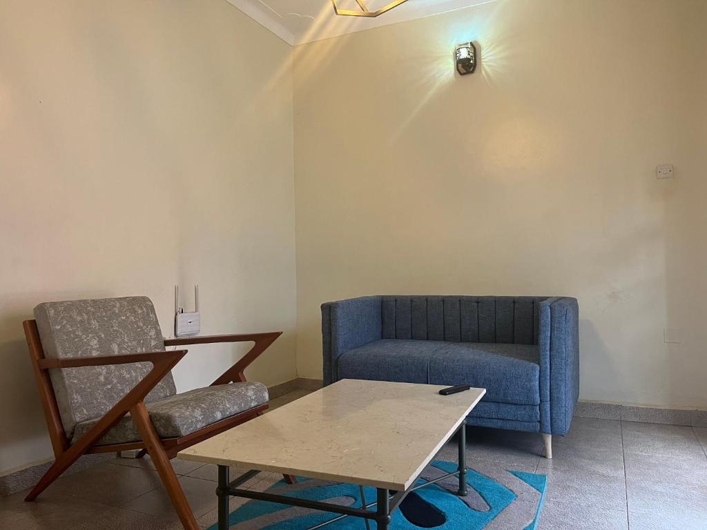 a living room with a blue couch and a table at Luxury 1 BER Apartment Bukoto in Kampala