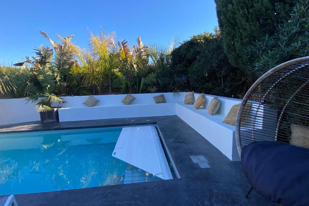 une piscine avec deux chaises et une table dans l'établissement Le Casot - Piscine - Plage - Parking - Wifi, à Sainte-Marie-la-Mer