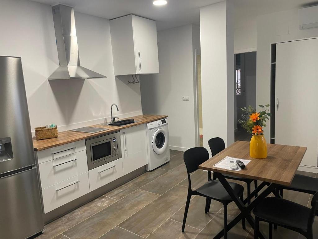 a kitchen with a table and a stove and a microwave at La Pitxotxa - Apartamento in Novelda