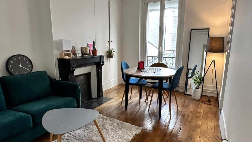 un salon avec un canapé vert et une table dans l'établissement Appartement cosy à Montmartre, à Paris