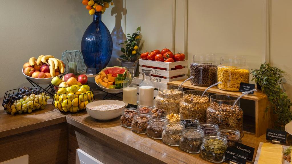 a table with bowls of fruit and jars of food at Eola Leisure Rooms in Stara Baška