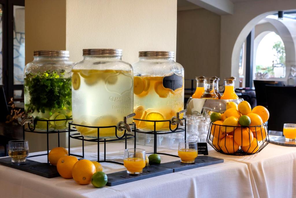 a table with three jars of lemonade and oranges at Eola Leisure Rooms in Stara Baška
