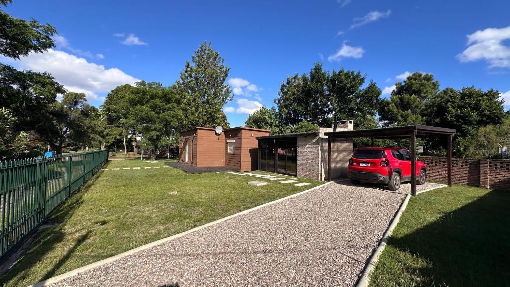 Un coche rojo aparcado delante de un edificio en Casitas Atlántida - casa 3, en Atlántida