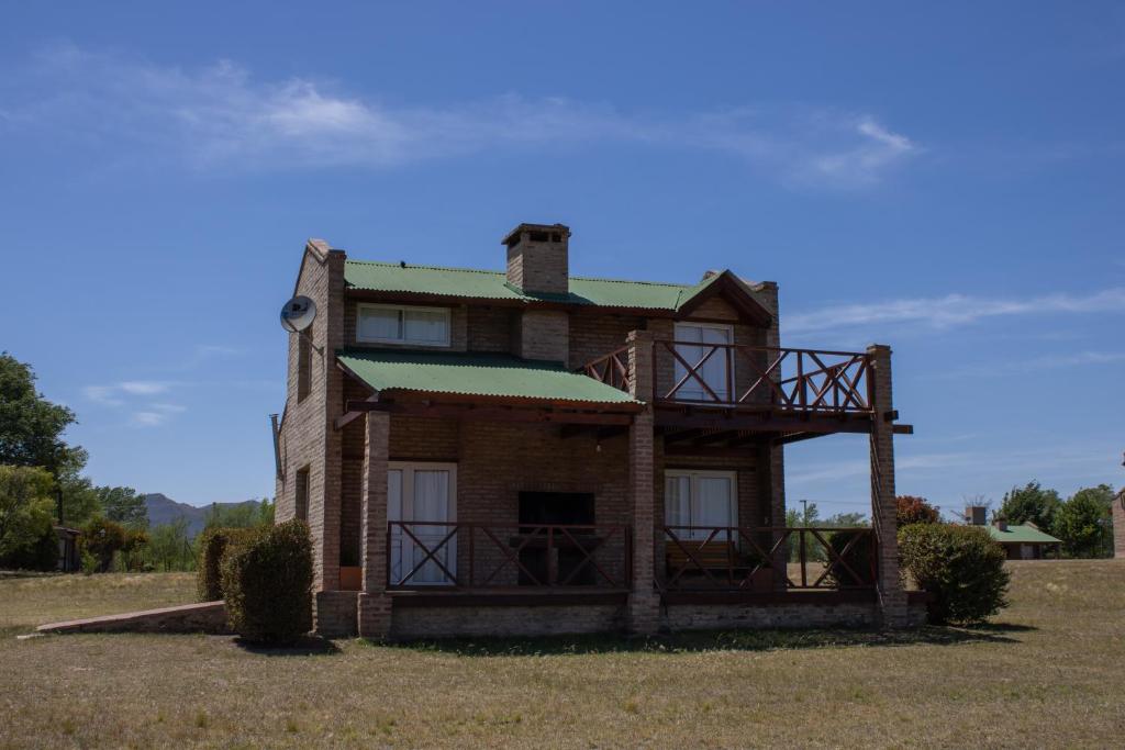 an old house sitting in the middle of a field at Complejo de cabañas- Lomas del Sol in Los Reartes