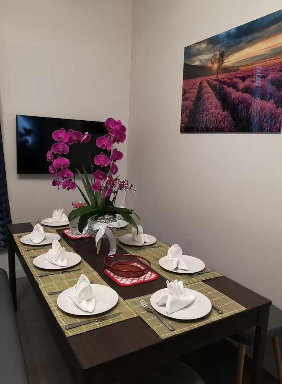 une table avec des plaques blanches et un vase de fleurs violettes dans l'établissement Mon Logis, à Paris