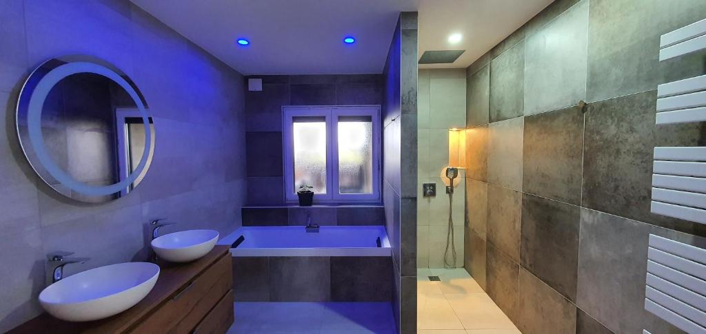 une salle de bain avec deux lavabos et un miroir dans l'établissement Appartement 3 pièces Strasbourg - Mundolsheim, à Mundolsheim