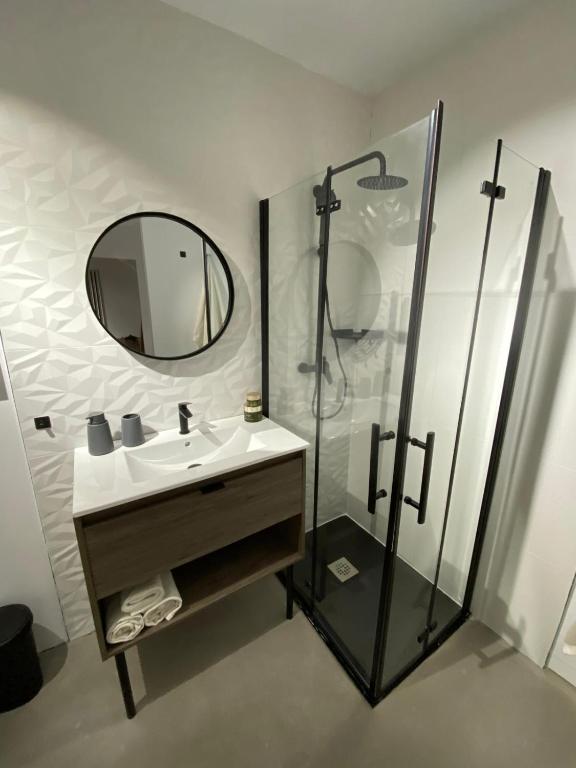 a bathroom with a sink and a shower with a mirror at Smart Residencial in Villanueva de la Cañada