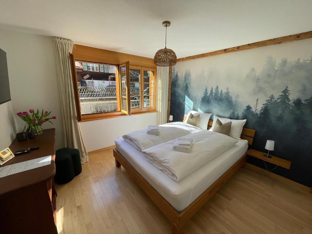 Un dormitorio con una cama grande con un cuadro en la pared. en Das Nest - nähe Terminal & Eiger view, en Grindelwald