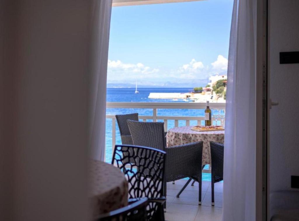 ein Balkon mit Tisch und Stühlen und Blick auf das Meer in der Unterkunft Vacation House Jadranko in Gdinj