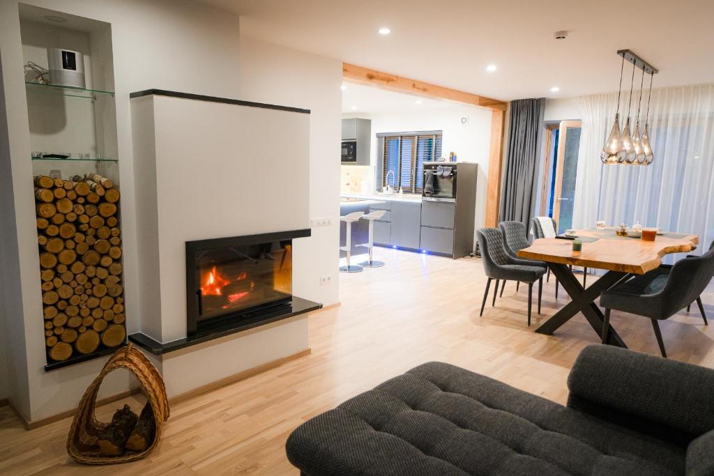 a living room with a fireplace and a dining room at Luxury Guest House - Hot Tub & Sauna in Valmiera