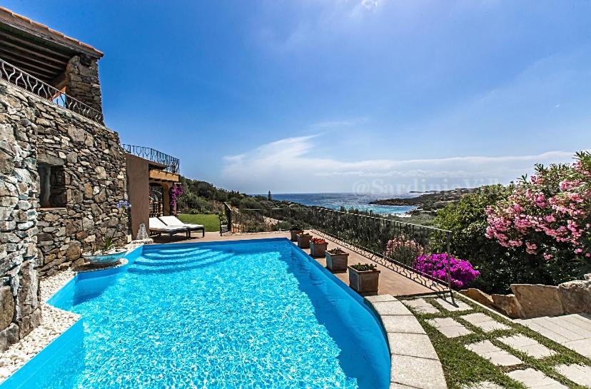 una piscina blu davanti a una casa di Villetta Belvedere 2 - Porto Cervo a Arzachena