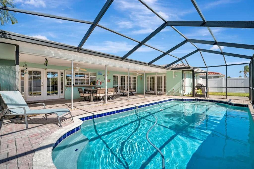 an indoor swimming pool with a glass roof over it at The Crown House 4b Pool Home 6 mins to IR Beach in Largo