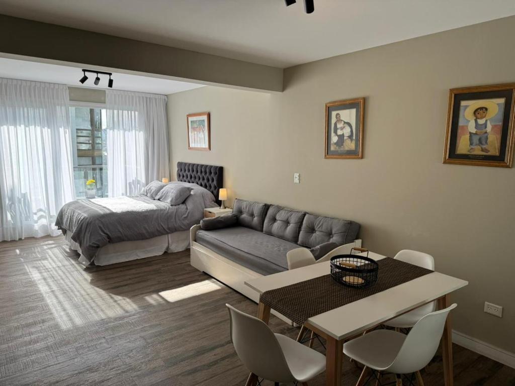 un salon avec un canapé et un lit dans l'établissement Departamento Güemes, à San Carlos de Bariloche