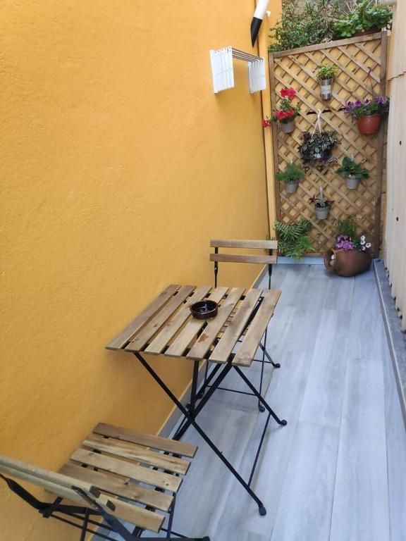 stół piknikowy i dwa krzesła obok ściany w obiekcie Casa bajada a la playa w mieście Beloso