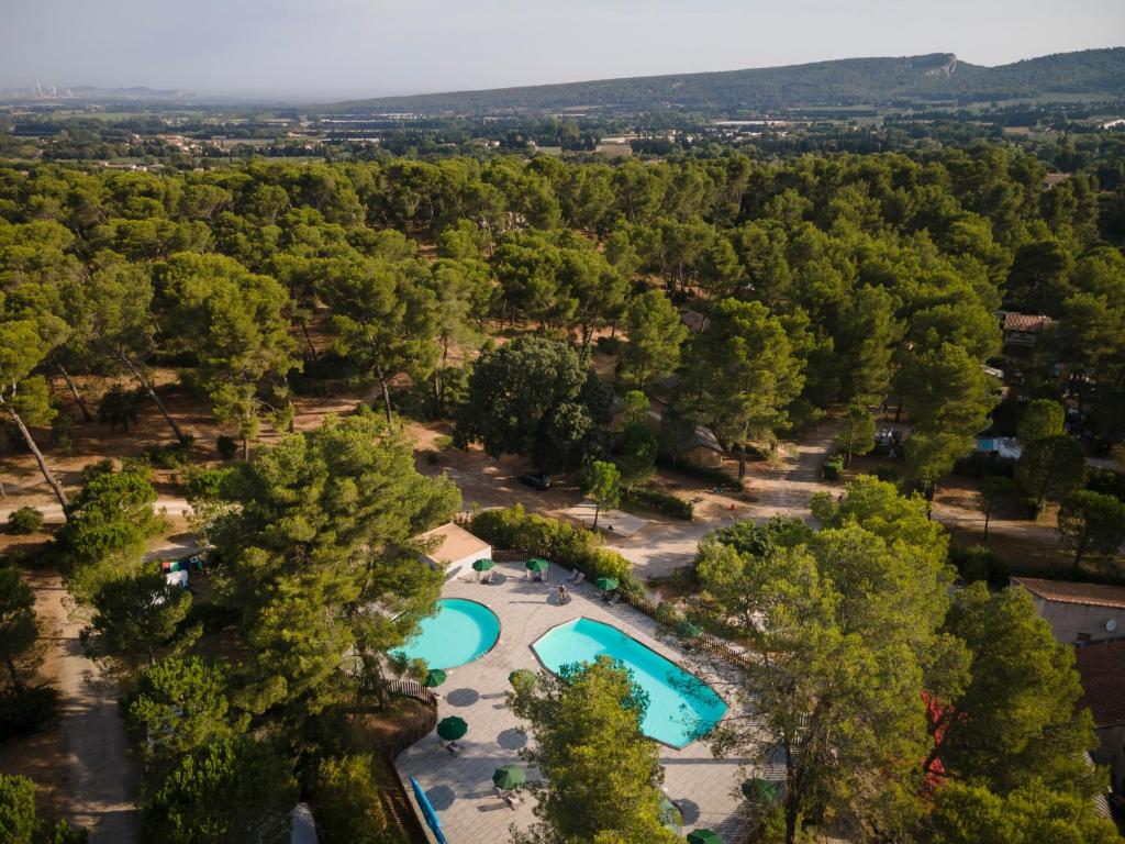 - une vue sur la piscine située dans un parc arboré dans l'établissement Huttopia Fontvieille, à Fontvieille