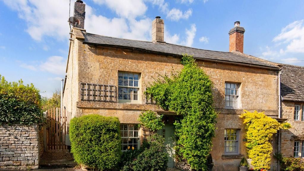 an old brick house with ivy growing on it at Mouse Manor in Longborough