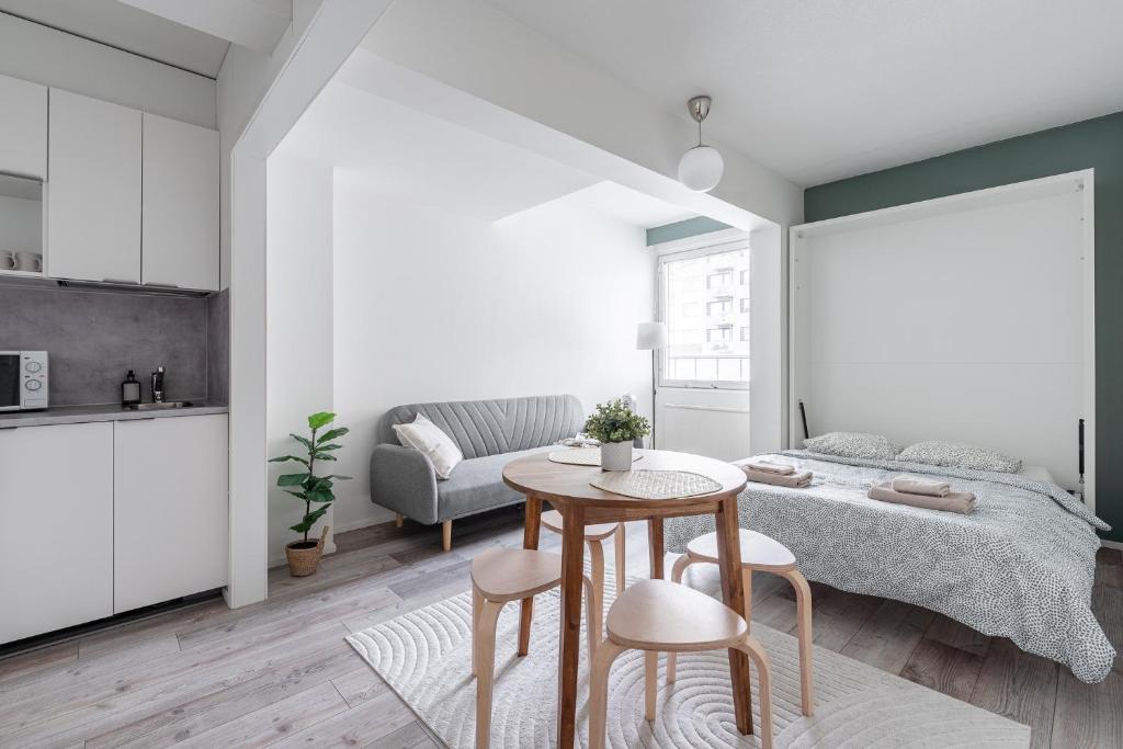 a bedroom with a bed and a table and chairs at Homelike Studio at the Very Center of Downtown Tampere in Tampella