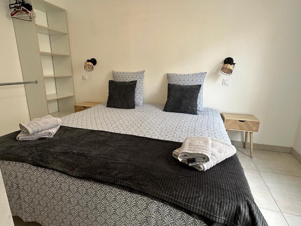 een slaapkamer met een groot bed met twee kussens bij Chez Camille & Emma - Climatisé in Rochefort